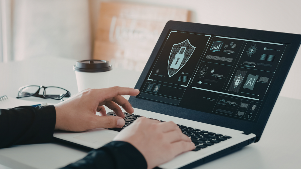 IT professional reviewing risk management frameworks and cybersecurity controls on laptop.