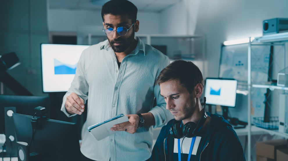 Two IT professionals discussing CISSP salary insights in a tech environment.